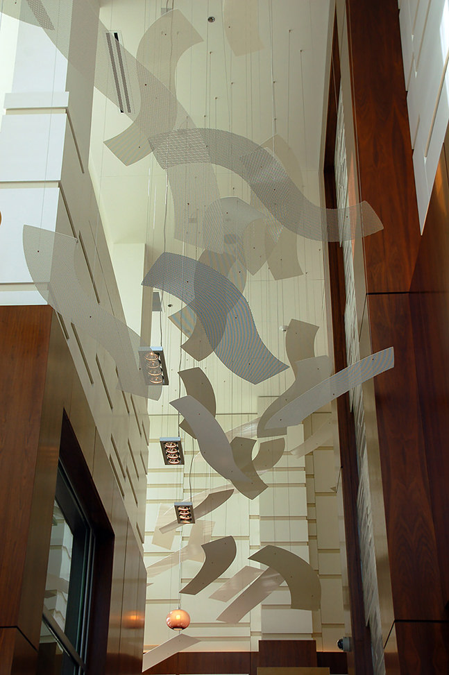 Talley Fisher's Rhythm of the Rails suspended art installation in a wood-lined lobby.
